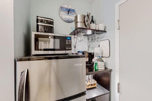 a microwave on top of a refrigerator in a kitchen at The Oceanfront Litchfield Inn 251 in Pawleys Island