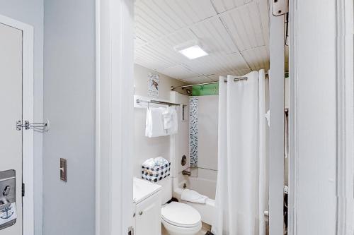 y baño blanco con aseo y ducha. en The Oceanfront Litchfield Inn 251 en Pawleys Island