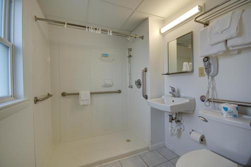 a bathroom with a shower and a toilet and a sink at Sahara Motel in Ocean City