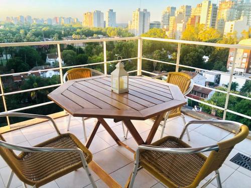 a wooden table and chairs on a balcony at Fantástico depto. con vistas panorámicas in Vicente López