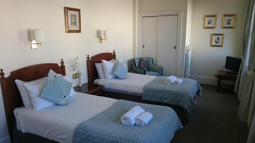 a hotel room with two beds with towels on them at 17 Wilmington Square in Eastbourne