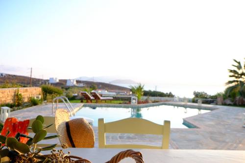 uma mesa e cadeiras em frente a uma piscina em Valea Villa em Agios Prokopios