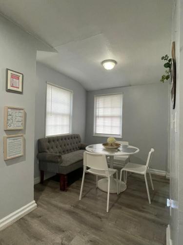 uma sala de estar com um sofá, uma mesa e cadeiras em Renovated guest house em Hyattsville