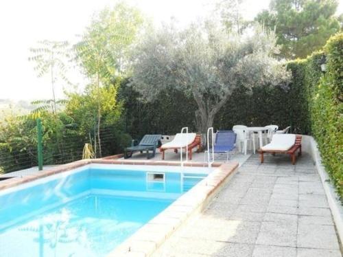una piscina con mesa y sillas junto a en Appartement in Catignano mit Whirlpool, Garten und Terrasse, en Catignano