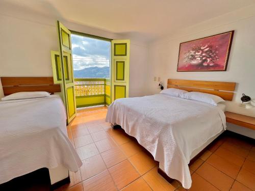 een slaapkamer met twee bedden en een groot raam bij HOTEL MONTE VERDE in Concordia