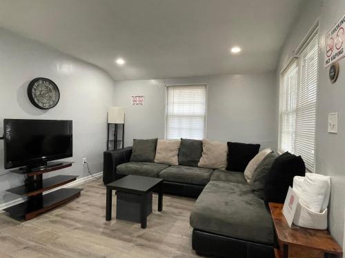 uma sala de estar com um sofá e uma televisão de ecrã plano em Renovated guest house em Hyattsville