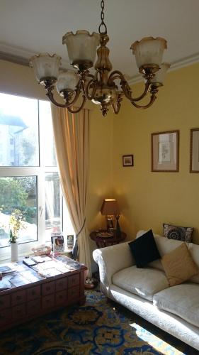 a living room with a couch and a chandelier at 17 Wilmington Square in Eastbourne