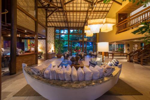 um grande lobby com um barco no meio de uma sala em Refúgio da Vila Boutique Hotel & SPA na Praia do Forte