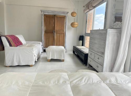 1 dormitorio blanco con 2 camas y vestidor en Monoambiente luminoso céntrico con cochera en San Nicolás de los Arroyos
