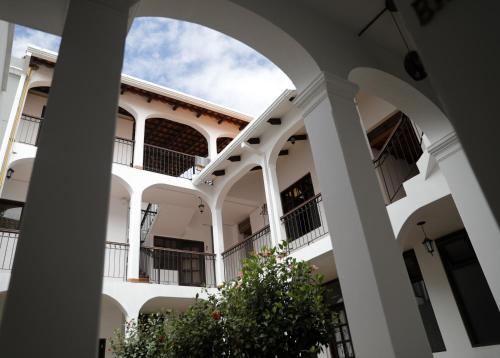 un edificio blanco con un arco y una planta en Olala house en Sucre