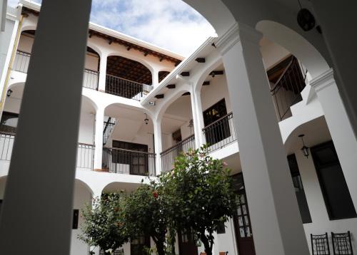 a white building with trees in front of it at Olala house in Sucre