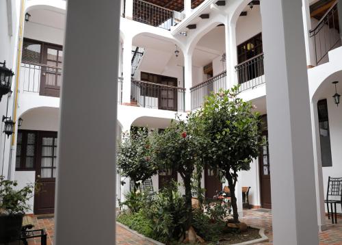 a white building with trees in the courtyard at Olala house in Sucre
