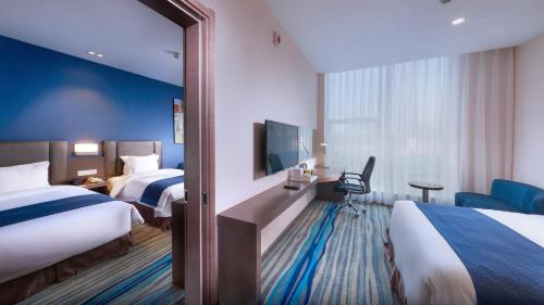a hotel room with two beds and a mirror at Holiday Inn Express Shenyang North Station by IHG in Shenyang