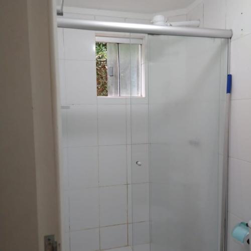 a glass shower door with a window in a bathroom at Apartamento no Lacqua DiRoma III, com complexo aquático Caldas Novas in Caldas Novas