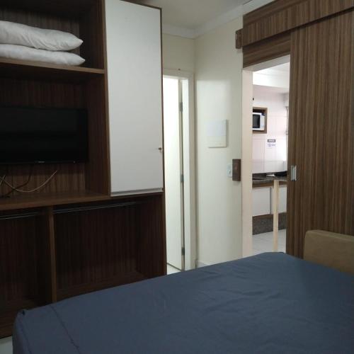 a bedroom with a bed and a flat screen tv at Apartamento no Lacqua DiRoma III, com complexo aquático Caldas Novas in Caldas Novas