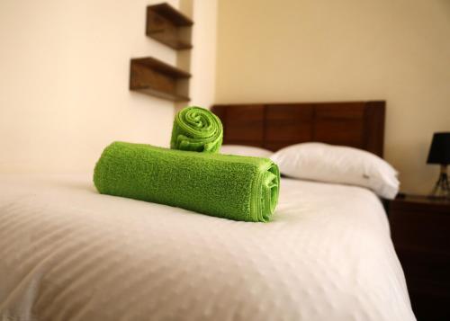 a green towel sitting on top of a bed at Olala house in Sucre