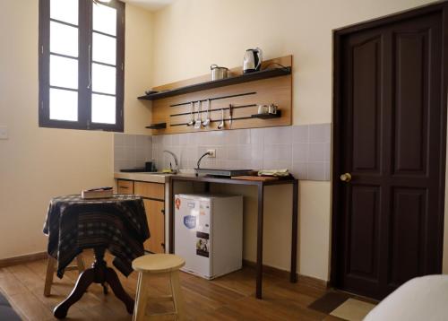a kitchen with a counter and a sink and a table at Olala house in Sucre