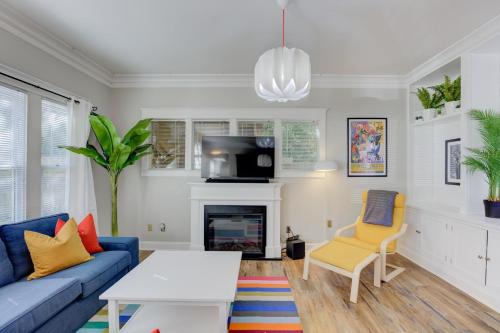 a living room with a blue couch and a fireplace at Hip and Spacious Midtown Cottage near Beale Street in Memphis