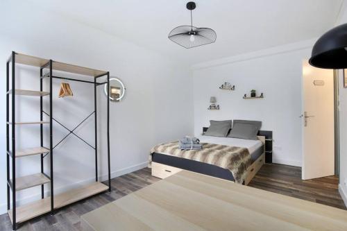 een slaapkamer met een bed en een boekenplank bij Coeur de Briquettes in Blagnac