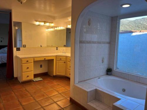 a bathroom with a tub and a sink and a mirror at 8 ACRES, Heated Salt Pool, Spa, Skyline Views, Mini-golf, Horseshoes, B-Ball Court, Hilltop Resort in Jamul