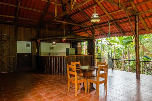 a dining room with a table and chairs on a tile floor at La Fortuna Natural Green in Fortuna