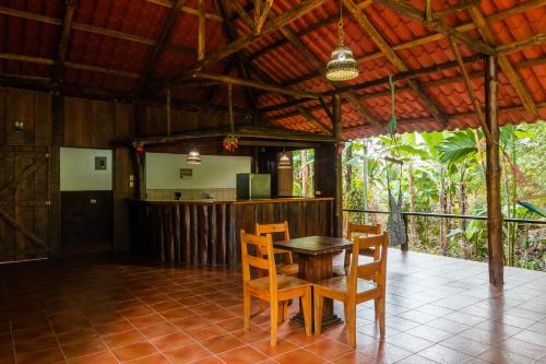 ein Esszimmer mit einem Tisch und Stühlen auf einem Fliesenboden in der Unterkunft La Fortuna Natural Green in Fortuna