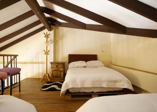 a bedroom with two beds and a wooden ceiling at Olala house in Sucre