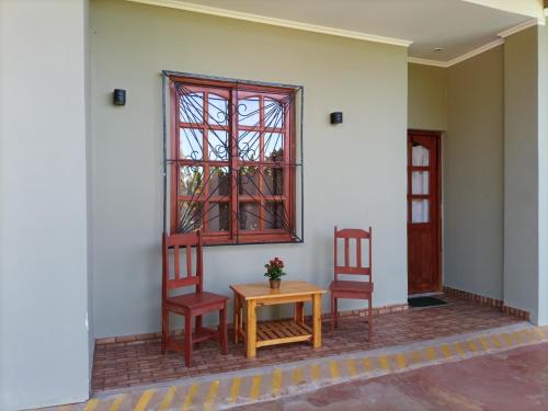 two chairs and a table in front of a window at Hotel Village del Sol in Puerto Iguazú