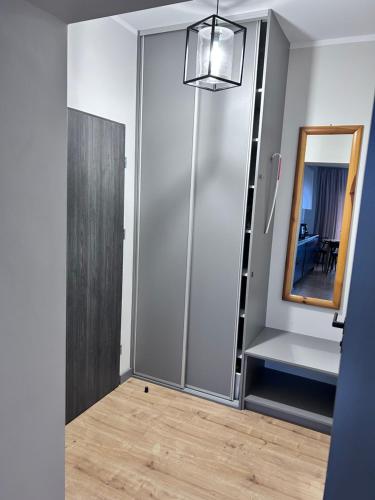 a room with a sliding door and a mirror at Apartament Walczaka 42 MIEJSCE PARKINGOWE in Gorzów Wielkopolski