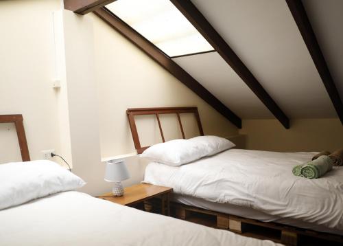 a attic room with two beds and a skylight at Olala house in Sucre