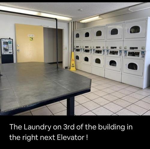 a laundry room with a table and washing machines at Lovely Condo 2 Bedrooms, 2 bathrooms, free 1 Parking at Waikiki Beach in Honolulu