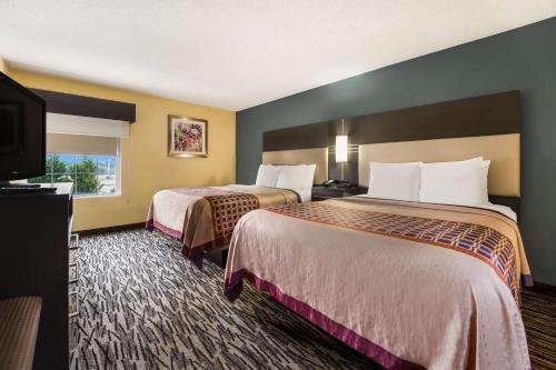 a hotel room with two beds and a flat screen tv at Best Western Bradbury Inn & Suites in Perry