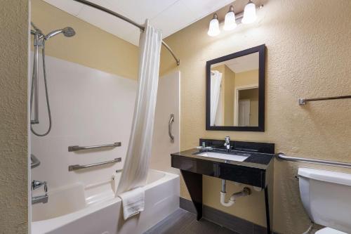 a bathroom with a sink and a tub and a mirror at Best Western Bradbury Inn & Suites in Perry