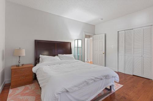 Dormitorio blanco con cama grande y cabecero de madera en Frog Hollow Red Door Retreat, en Hartford