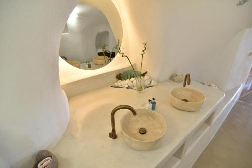 a bathroom with two sinks and a mirror at Maria Paradeiso Resorts in Imerovigli