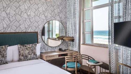 a bedroom with a bed and a desk and a mirror at Suncoast Hotel & Towers in Durban