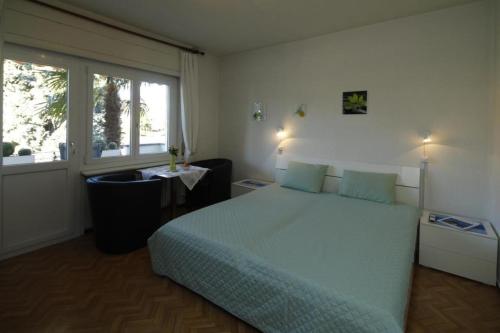een slaapkamer met een groot bed en een raam bij Casa Thuja in Ascona