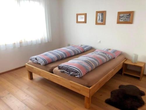 a bed with pillows on it in a room at Aiolos Apartments 6 Personen in Zermatt
