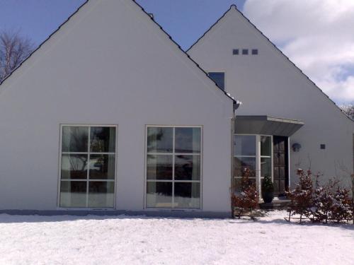 a white house in the snow at Helts B&B - Helts Guesthouse in Herning