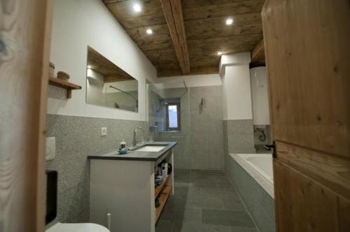 施庫爾的住宿－Chasa Florinja，浴室配有盥洗盆和浴缸。