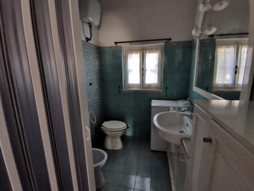 uma casa de banho com um WC branco e um lavatório. em Tenuta Solleone em Peschici