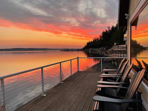 a group of chairs sitting on a dock near the water at WhidbeyBeachHouse, an Oceanfront Getaway on a Private Beach in Langley