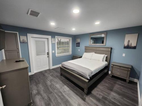 a bedroom with blue walls and a bed and a desk at Paradise on Lake Harris Apt #202 in Leesburg