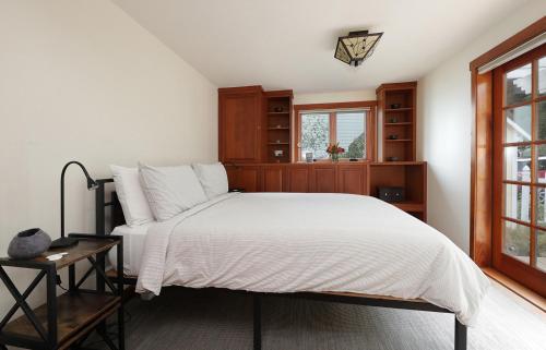 a bedroom with a white bed and a window at WhidbeyBeachHouse, an Oceanfront Getaway on a Private Beach in Langley