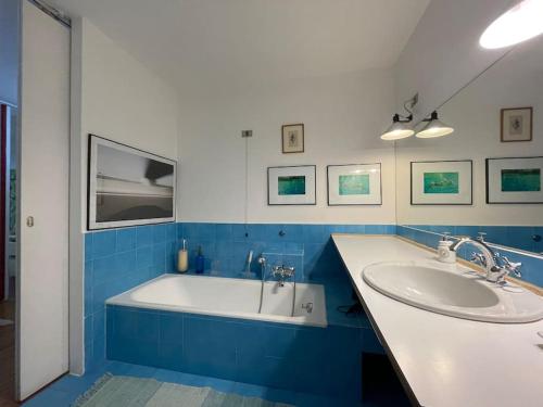 een blauwe en witte badkamer met een bad en een wastafel bij Grande appartamento in area storica di Bergamo in Bergamo