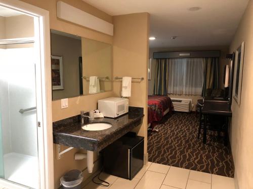 a hotel room with a bathroom with a sink and a bed at Casa Royal Inn in San Jose