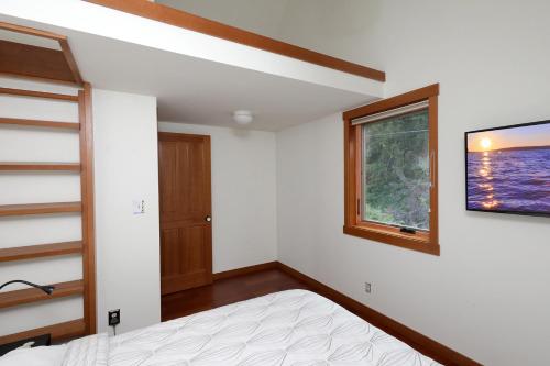 a bedroom with a bed and a window at WhidbeyBeachHouse, an Oceanfront Getaway on a Private Beach in Langley