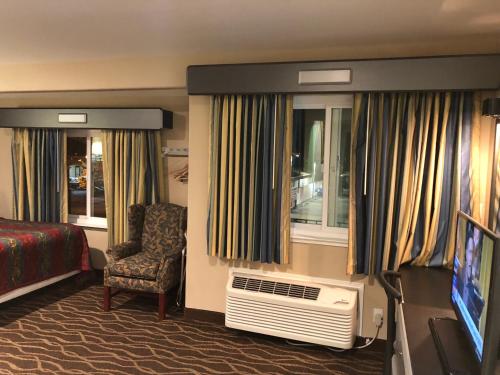 a hotel room with a tv and a bedroom at Casa Royal Inn in San Jose