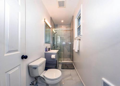 a white bathroom with a toilet and a shower at Boston Modern 7 Bedroom 2.5 Bath in Boston