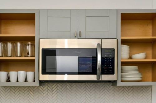 a microwave in a kitchen with white cabinets at Boston Historical Urban Oasis in Boston